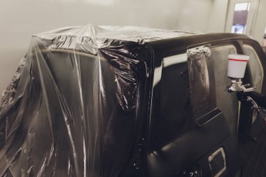 Boya kabininde araba boyayan bir işçi.,