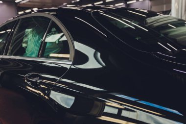 Adam arabayı su basıncıyla yıkıyor, araba tamiri yapıyor, araba cilası için hazırlık yapıyor..