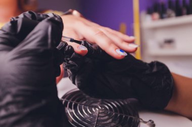 Güzellik salonunda manikür yapan bir kadın. Ellerin yakın çekimi.