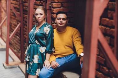 Genç ve modaya uygun erkek ve kadın modeller sokakta yürüyor. Eski kasabada. Moda Biçimi.