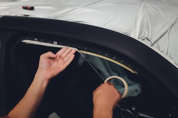 Mechanic preparing a car for painting by protecting the edges. — Stock Photo, Image