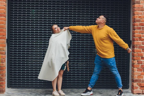 Des mannequins hommes et femmes jeunes et branchés marchent dans la rue. dans la vieille ville. Style de mode. — Photo