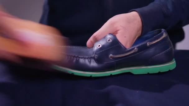 一个男人在画鞋子，蓝色的鞋油，漆过的黄褐色皮鞋，一双漆过的男鞋. — 图库视频影像