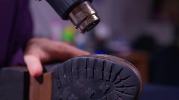 Calzolaio riscaldare il fondo della scarpa hes facendo incollare la suola. Il calzolaio è al lavoro nella sua fabbrica di scarpe da laboratorio. — Video Stock
