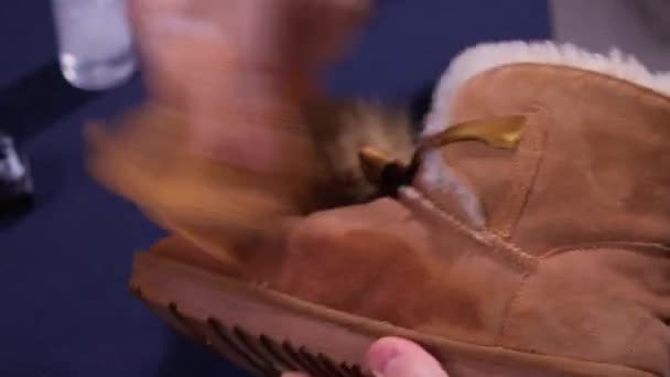 Manos limpiando mens bota de zapato desierto de gamuza camello con un cepillo. Mantenimiento del calzado capturado desde arriba. — Vídeos de Stock