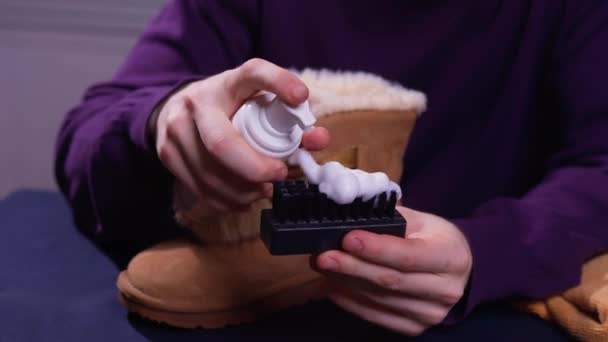 Hands cleaning mens camel suede desert shoe boot with a brush. Footwear maintenance captured from above top view. — Stock Video