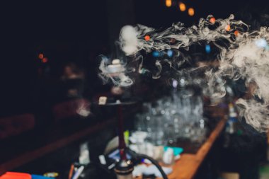 Siyah bir arka planda beyaz bir duman halkası. Duman arka planda yayılıyor. Vape kültürü. Kavramsal resim.