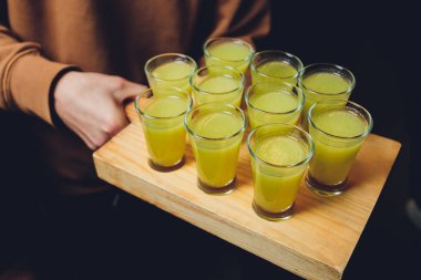 İçki endüstrisinde içki servisi için kullanılan servis tepsisindeki shot kadehlerinde çeşitli alkollü içkiler..