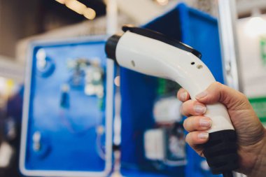 Yeni enerji elektrikli araba hibrid şarj istasyonuna bağlanıyor. Yeni otomobil icatları, arabanın şarj edilmesi, ulaşımın geleceği, Eco araba kavramı..