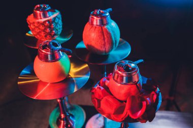 Duman ve ahşap masa tuğlasında kırmızı kıvılcımlar olan kırmızı shisha nargilesi, sanat arka planı. Shisha Kavramı.