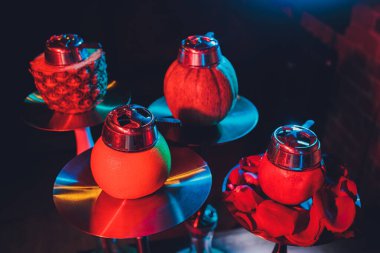 Duman ve ahşap masa tuğlasında kırmızı kıvılcımlar olan kırmızı shisha nargilesi, sanat arka planı. Shisha Kavramı.