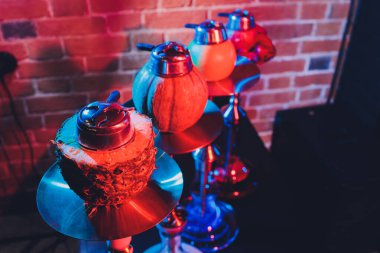 Duman ve ahşap masa tuğlasında kırmızı kıvılcımlar olan kırmızı shisha nargilesi, sanat arka planı. Shisha Kavramı.