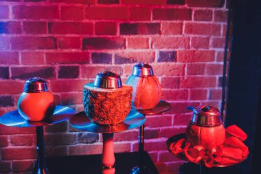 Duman ve ahşap masa tuğlasında kırmızı kıvılcımlar olan kırmızı shisha nargilesi, sanat arka planı. Shisha Kavramı.