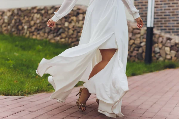 Κοντινό πλάνο μιας νύφης που χορεύει στο δρόμο. Μέρος του σώματος. Γυναίκα με φωτεινό φόρεμα που χορεύει στα πόδια του δρόμου. Γυναικεία πόδια. Σέξι ωραία πόδια. Δέρμα. Παπούτσια μοδάτα. — Φωτογραφία Αρχείου