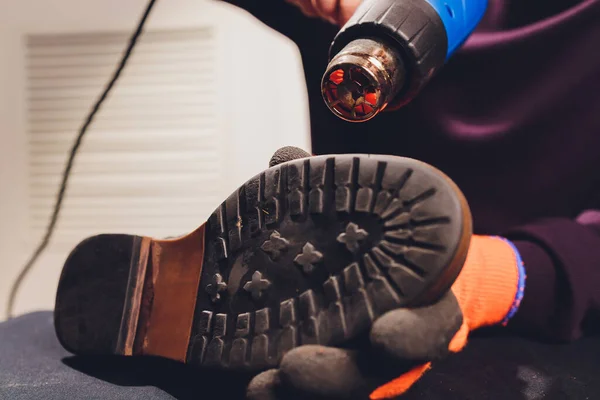 구두끈으로 구두 밑부분을 가열하여 발바닥에 접착제를 붙이는 것이다. 코블러는 작업장 신발 공장에서 일하고 있다. — 스톡 사진