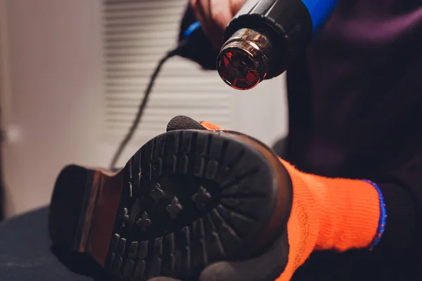 구두끈으로 구두 밑부분을 가열하여 발바닥에 접착제를 붙이는 것이다. 코블러는 작업장 신발 공장에서 일하고 있다. — 스톡 사진