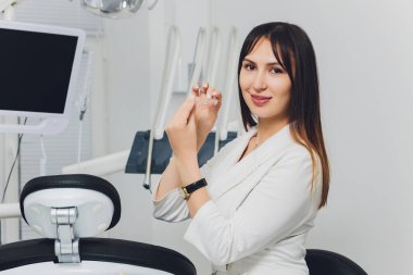 Çekici, gülümseyen, elleri bağlı bir dişçinin portresi..