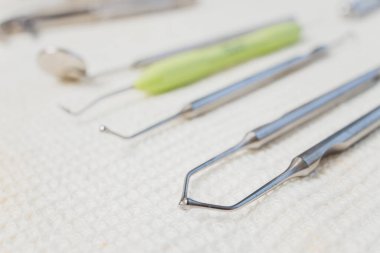Metalik dişçi aletleri. Dişçi dişçi matkabı olarak metal kafayı seçiyor. Dişçi kliniği..