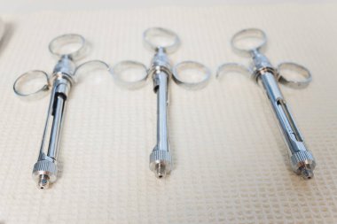 Metalik dişçi aletleri. Dişçi dişçi matkabı olarak metal kafayı seçiyor. Dişçi kliniği..