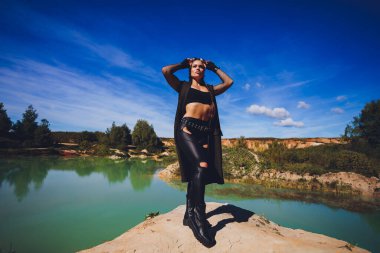 Kirli bir gölün arka planına karşı Steampunk kıyafeti giymiş bir kadın..