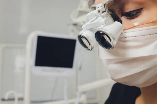 돋보기와 마스크를 착용 한 특수 안경을 쓴 주물 치과 의사. 의사들. — 스톡 사진