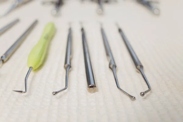 Sada kovových zubařských nástrojů. Zubař si vybere kovovou hlavu pro zubařskou vrtačku. Zubařská klinika. — Stock fotografie
