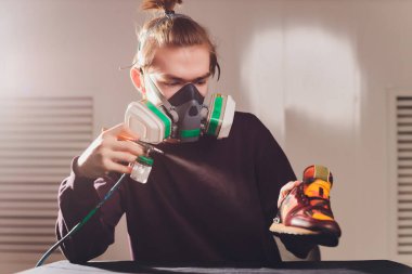 Teknisyen bir çift ayakkabı boyuyor. Boya ve süet spor ayakkabıları..