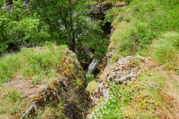 Vue naturelle des champs verdoyants au premier plan et des montagnes de falaises et de collines en arrière-plan par une journée d'été ensoleillée. — Photo