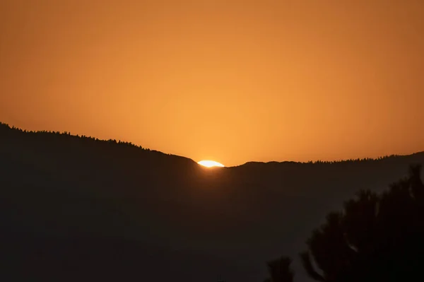 Farbige orangefarbene Sonne hinter den Bergen. — Stockfoto