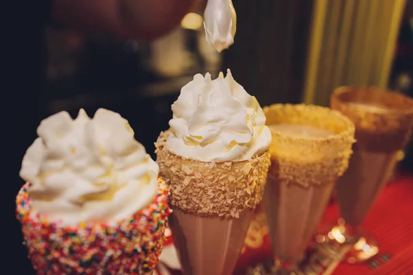 Bicchieri di frullato, frappe, caffè ghiacciato e frullato con panna montata. — Foto Stock