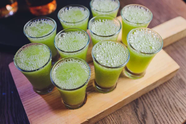 Variation of hard alcoholic shots served on bar counter. Blur bottles on background.