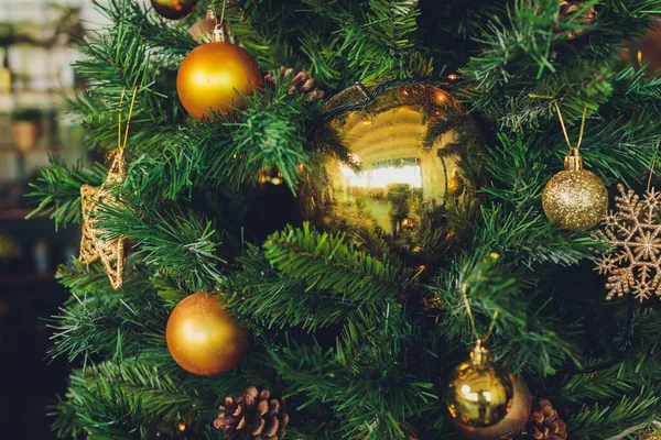 Gros plan de sapin de Noël décoré d'or, jouets, boules et guirlandes. Vacances d'hiver traditionnelles Noël Nouvel An. — Photo