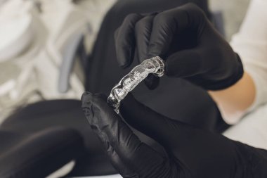 Bir Kadın Eli 'nin Dişe Şeffaf Hizalayıcısının Yakın Çekimi.