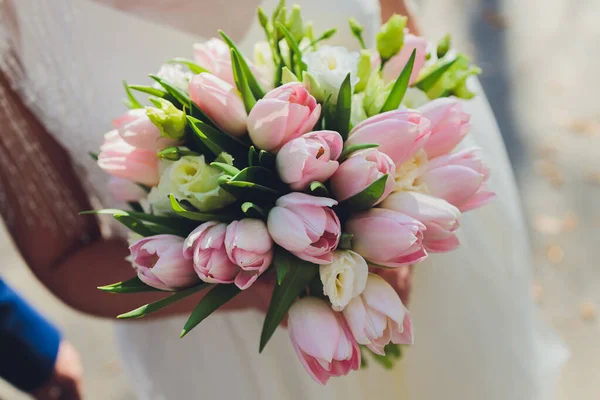 Bouquet de mariée avec des tulipes roses dans les mains de la mariée. — Photo