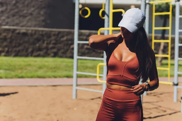 Una hermosa joven se dedica a los deportes en un simulador de calle. Concepto de buena forma física y estilo de vida saludable. — Foto de Stock