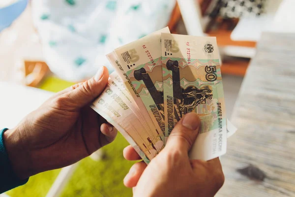 Russische Rubel in der Hand einer fan.male Hand, die viele der russischen Banknoten hält. Der Geldtransfer. Das isolierte Fünftausendstel der russischen Rubel-Stückelungen in einer Hand. — Stockfoto