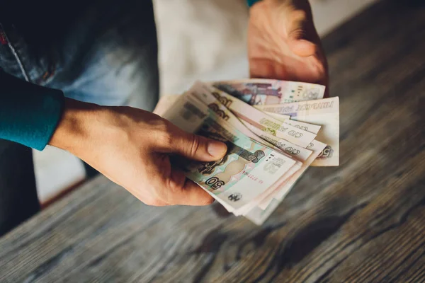 Russische Rubel in der Hand einer fan.male Hand, die viele der russischen Banknoten hält. Der Geldtransfer. Das isolierte Fünftausendstel der russischen Rubel-Stückelungen in einer Hand. — Stockfoto