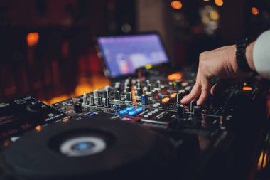 DJ 'ler ses ayarlarını kontrol eden dizüstü bilgisayarı ve konsolu karıştırıyor.