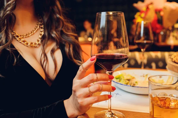 Chica joven sosteniendo vaso de martini con bebida roja en el bar. —  Fotos de Stock