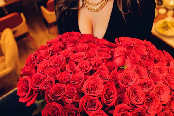 Piękna kobieta dekolt trzyma w ręku czerwoną różę. — Zdjęcie stockowe