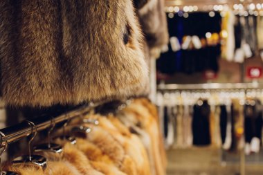 Askıdaki bir dükkanda farklı renklerde vizon kürkler.