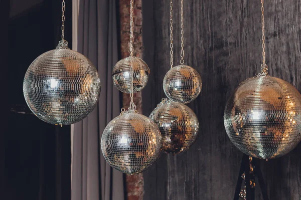 Gnistrande disco boll hängande i ett tomt grinigt rum. — Stockfoto