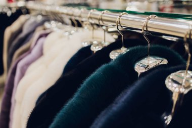 Lüks vizon kürkler. Market vitrininde gri, kahverengi, inci renkli kürk mantolar. Kadınlar için en iyi hediye vizon kürktür. Giysiler. Kapat..