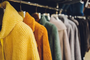 Mağazadaki askıların üzerinde paltolar ve ceketler. Dış giyim satışı.