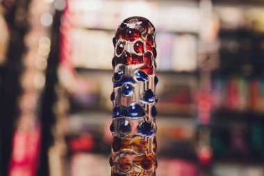 Anal glass butt plug with a fluffy tail with female hands. Toy for adult games.