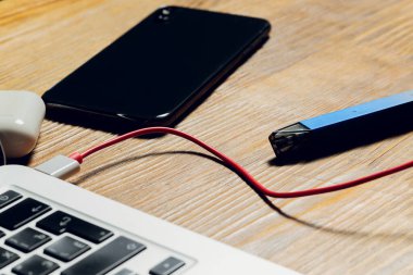 POD e-sigara veya nikotin buhar makinesi modern dizüstü bilgisayarda Podlarla şarj ediliyor.