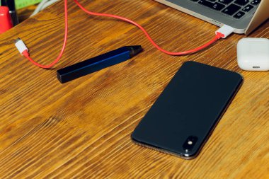 POD e-sigara veya nikotin buhar makinesi modern dizüstü bilgisayarda Podlarla şarj ediliyor.