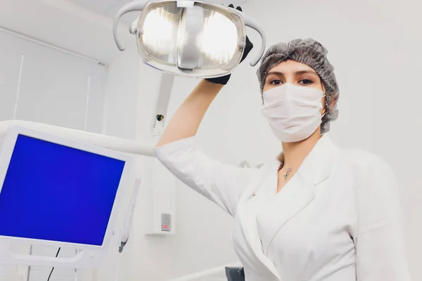 Porträt einer attraktiven lächelnden Zahnärztin mit gefalteten Händen. — Stockfoto