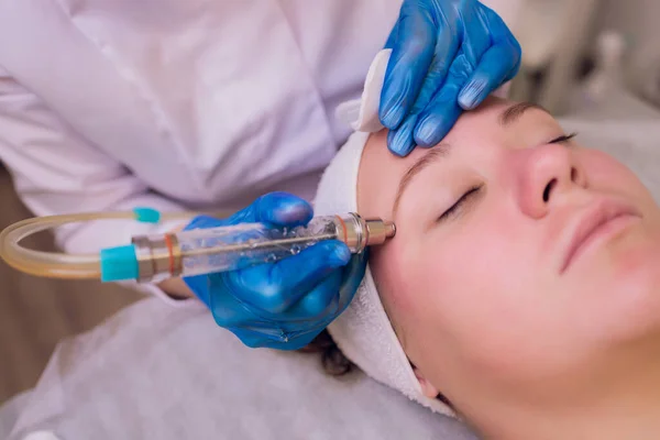 Vrouw schoonmaken van de huid poriën met behulp van vacuüm blackhead remover, cosmetische procedure. — Stockfoto