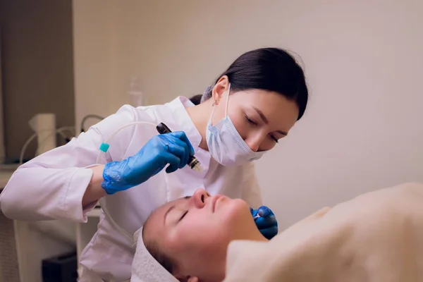 Woman cleaning nose skin pores using vacuum blackhead remover, cosmetic procedure.